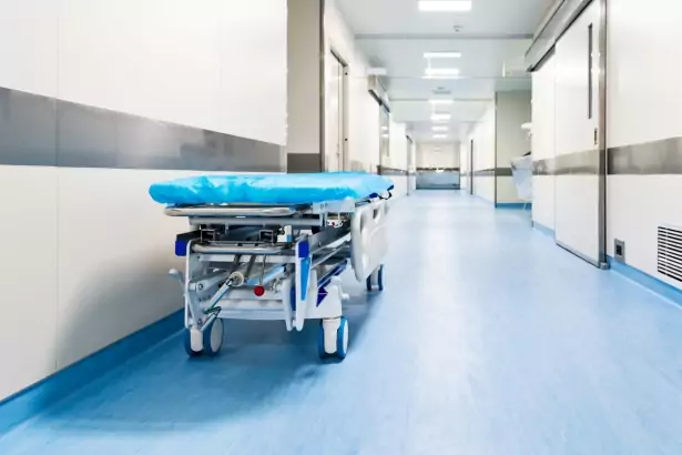 Empty hospital bed in empty hospital corridor