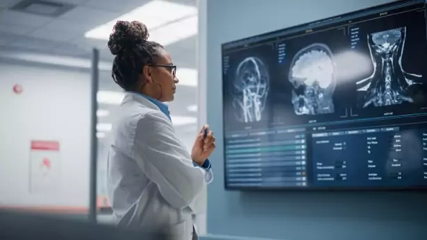 Ai in healthcare: Confident Black Female Neurologist studying MRI scan on screen in hospital