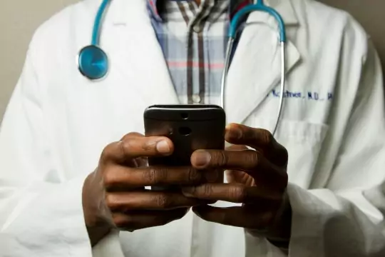 A doctor looking at patient medical records on his phone