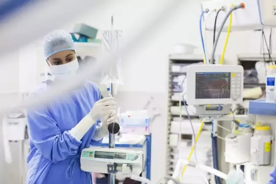 Nurse standing by and monitoring medical equipment